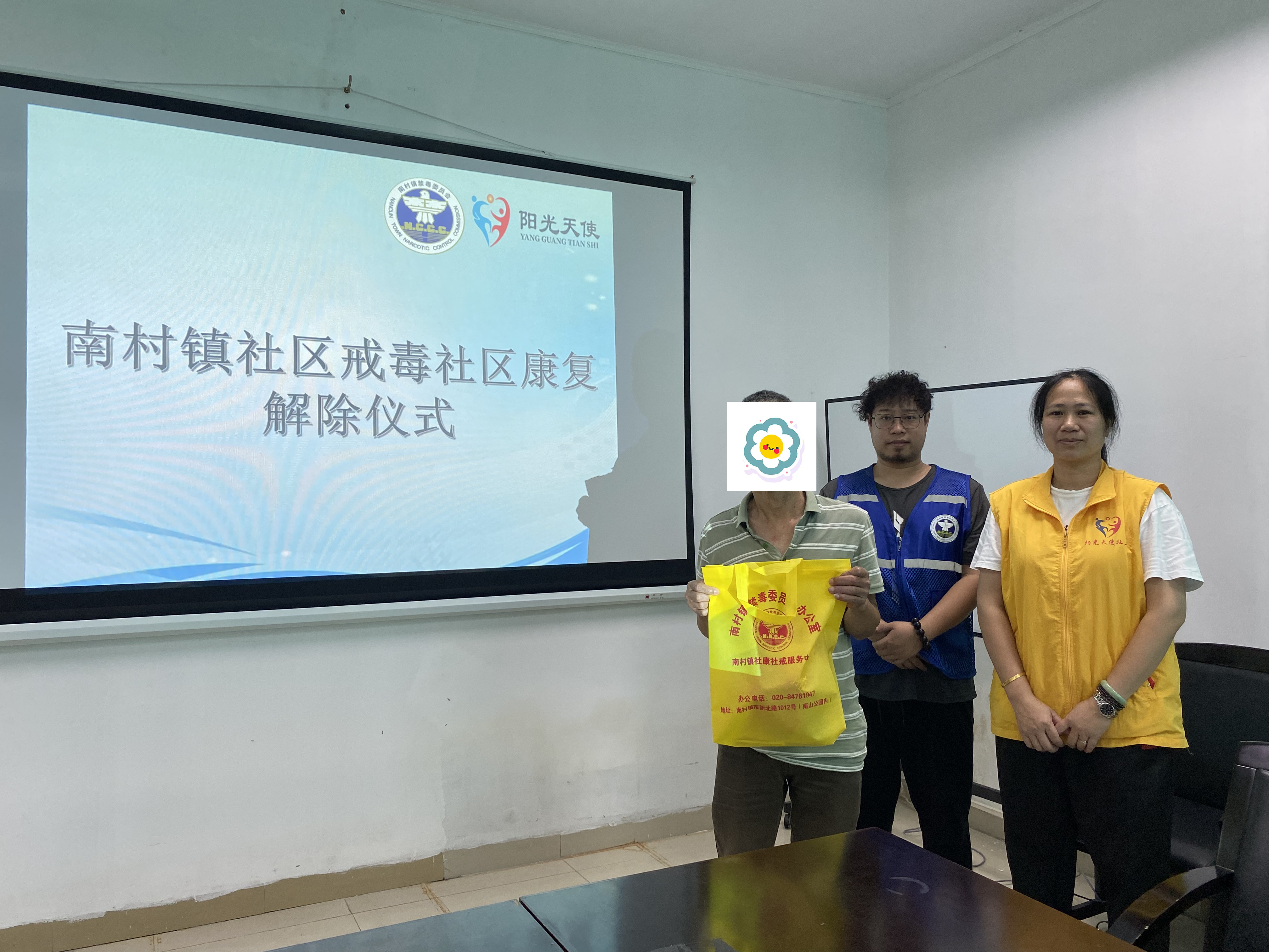 工作人员赠送纪念品给期满解除人员