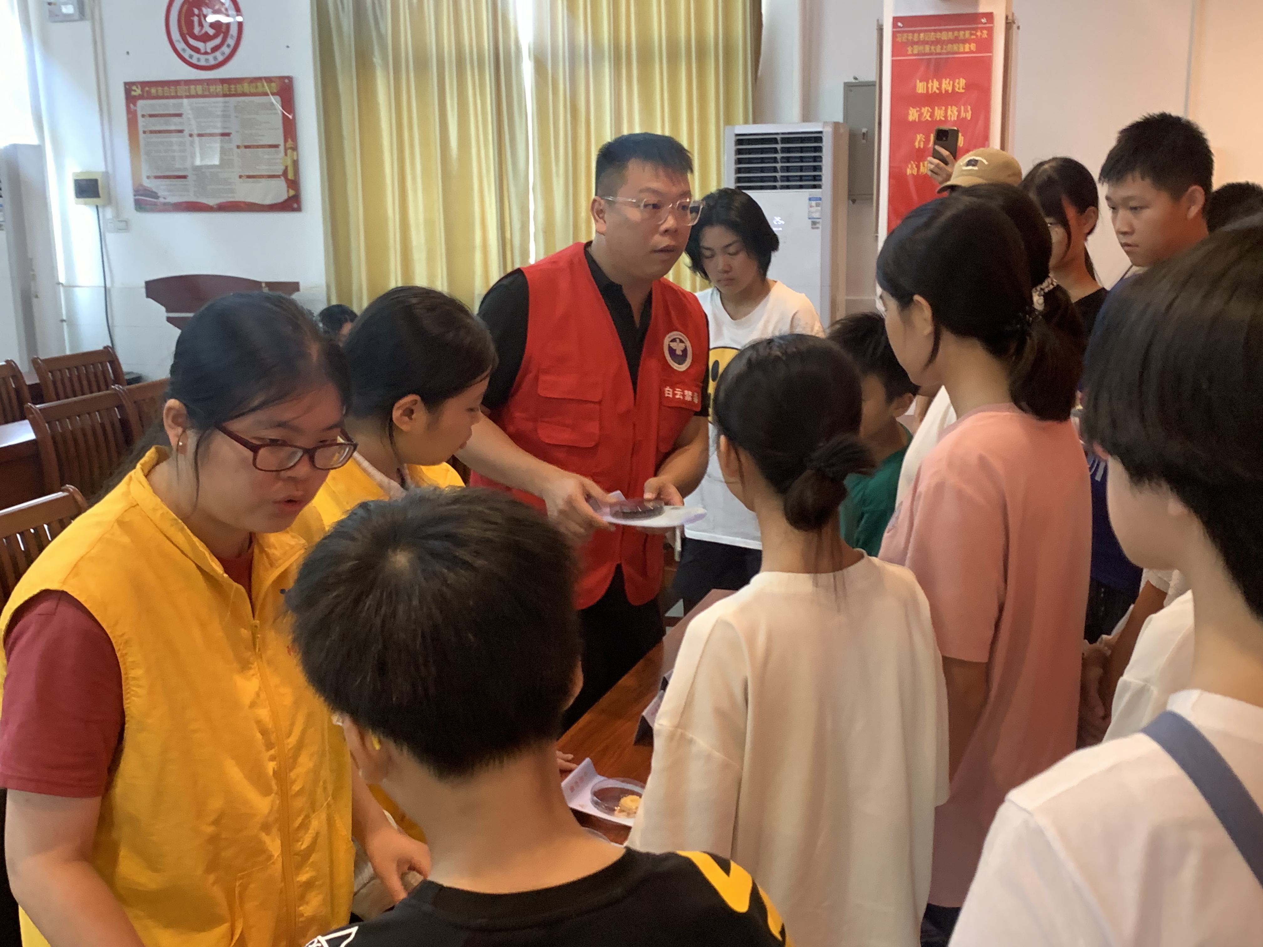 禁毒专职和社工给志愿者讲解仿真毒品